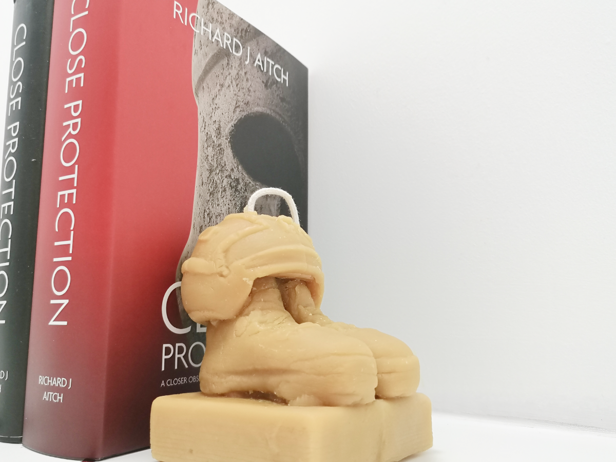 The veterans candle used as a bookend, propping up two close protection books by richard aitch